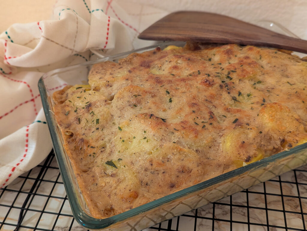 Gratin de pommes de terre à la béchamel aux bolets, gratiné et servi dans un plat en verre.